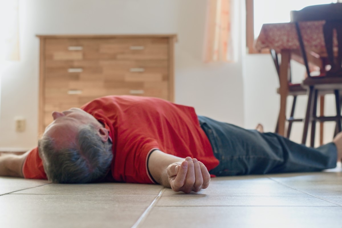 En medvetslös man ligger på golvet i ett hus