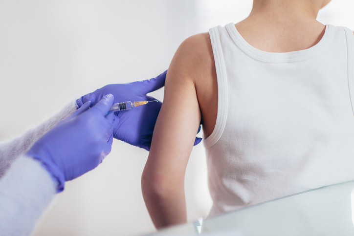 Vaccination - läkaren injicerar barnet med ett vaccin 