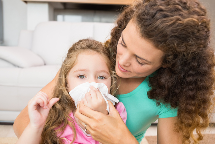 Barnet har en rinnande näsa, mamman blåser näsan full av sekret, en full näsa för allergier