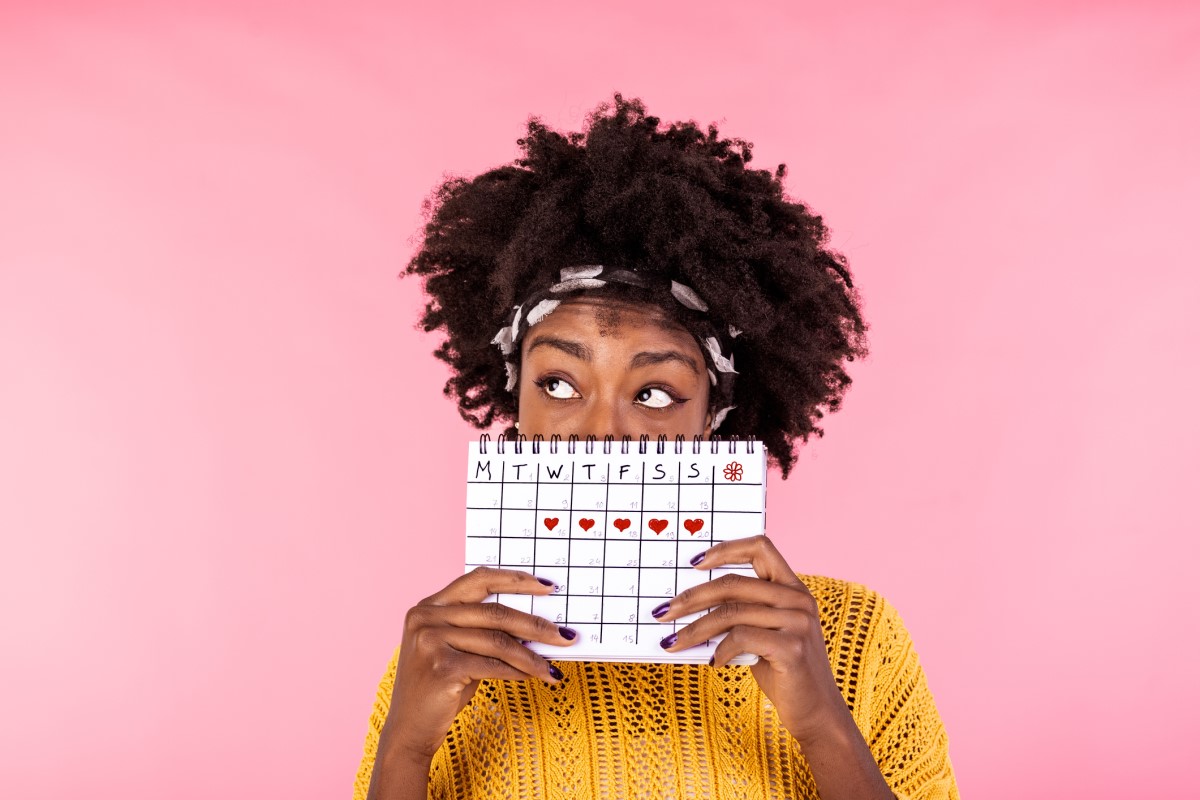 Kvinna som håller i en menstruationskalender