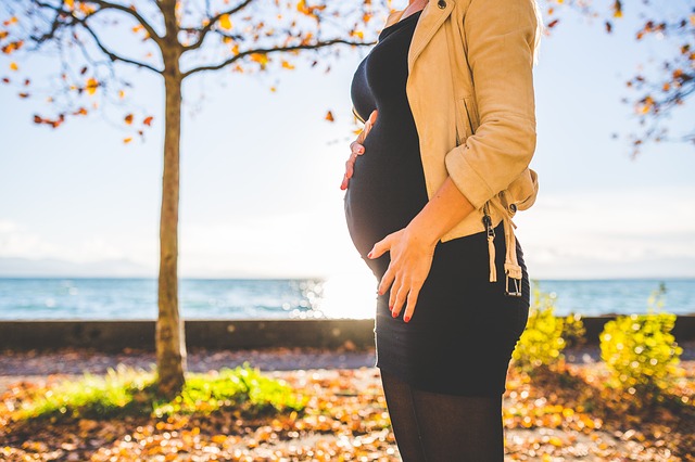 gravid kvinna framför träd höst